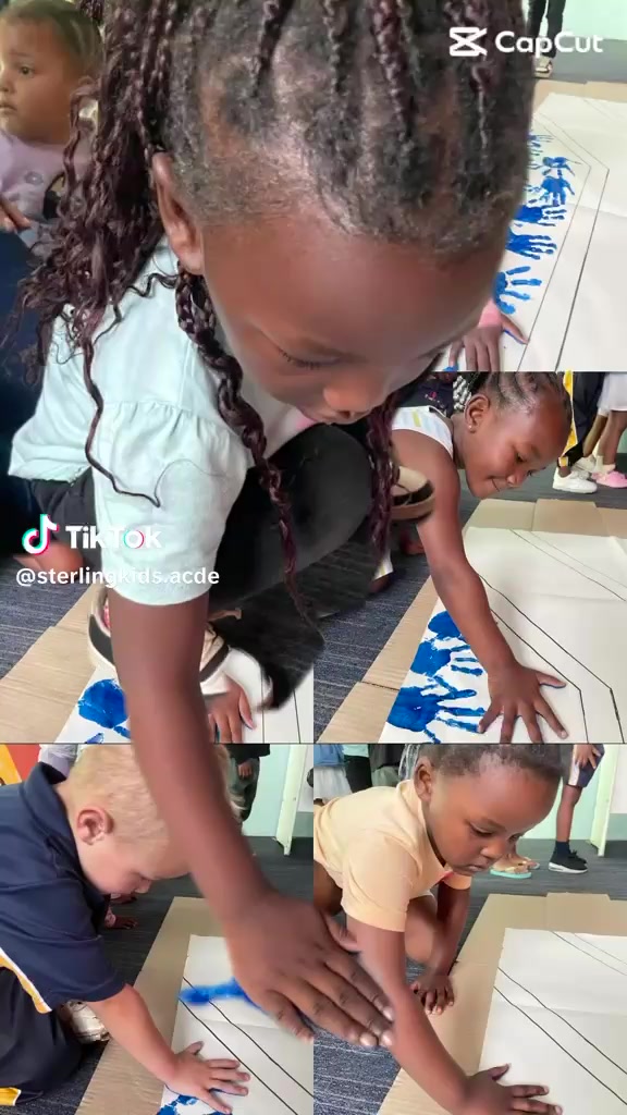 Children press paint-covered hands onto paper during a handprint activity.